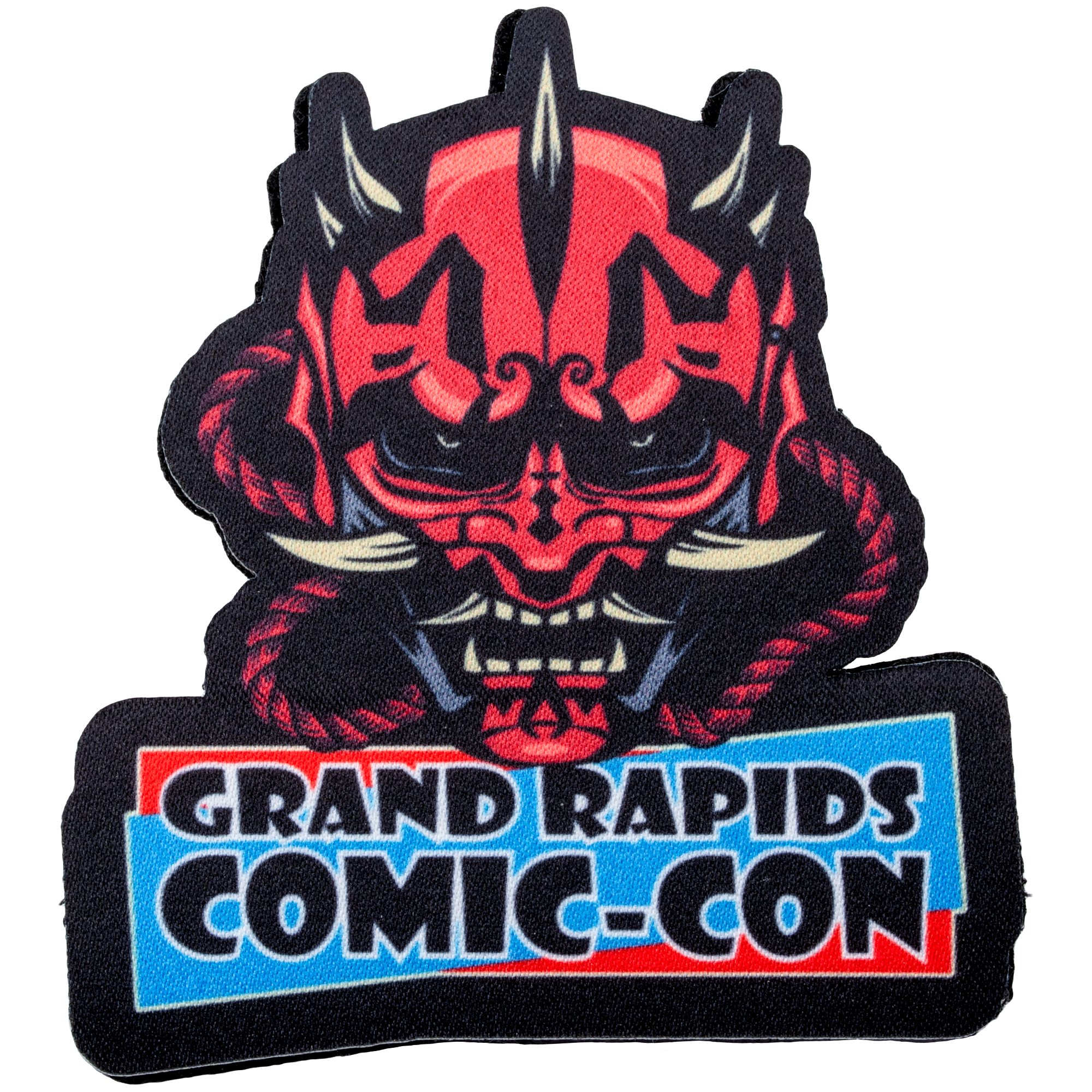 Embroidered patch for Grand Rapids Comic-Con featuring a red and black horned demon mask with tusks.