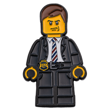 challenge coin shaped like a toy building block figure wearing a suit, striped tie, and a gold police badge.