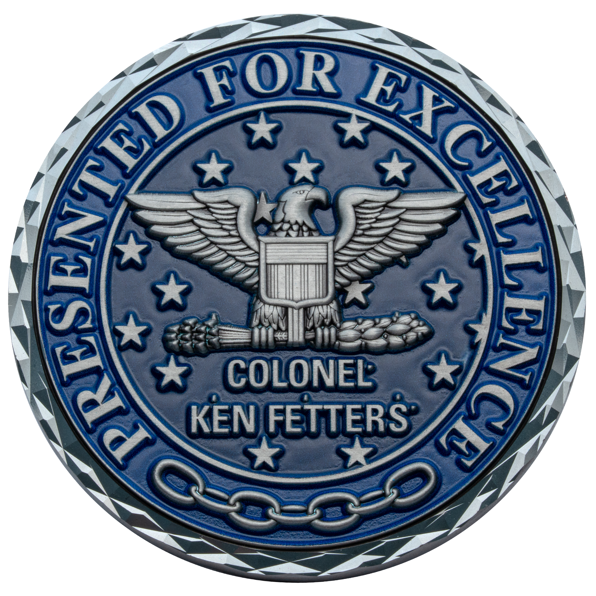 A circular blue challenge coin featuring a silver eagle with a shield, stars, and the text Colonel Ken Fetters Presented for Excellence.