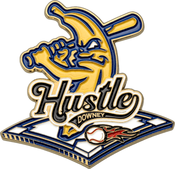 Enamel lapel pin featuring a banana mascot swinging a baseball bat over a diamond with a flaming baseball and the text Hustle Downey.