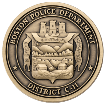 Antiqued bronze circular coin for Boston Police Department District C-11 featuring a detailed crest with a castle, landscape, and Latin mottos.