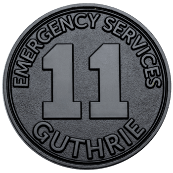 Circular black challenge coin featuring the number 11 with Emergency Services and Guthrie text in raised lettering.