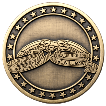 Antiqued gold challenge coin featuring an eagle holding a banner with the text Our Liberties We Prize and Our Rights We Will Maintain, surrounded by stars.