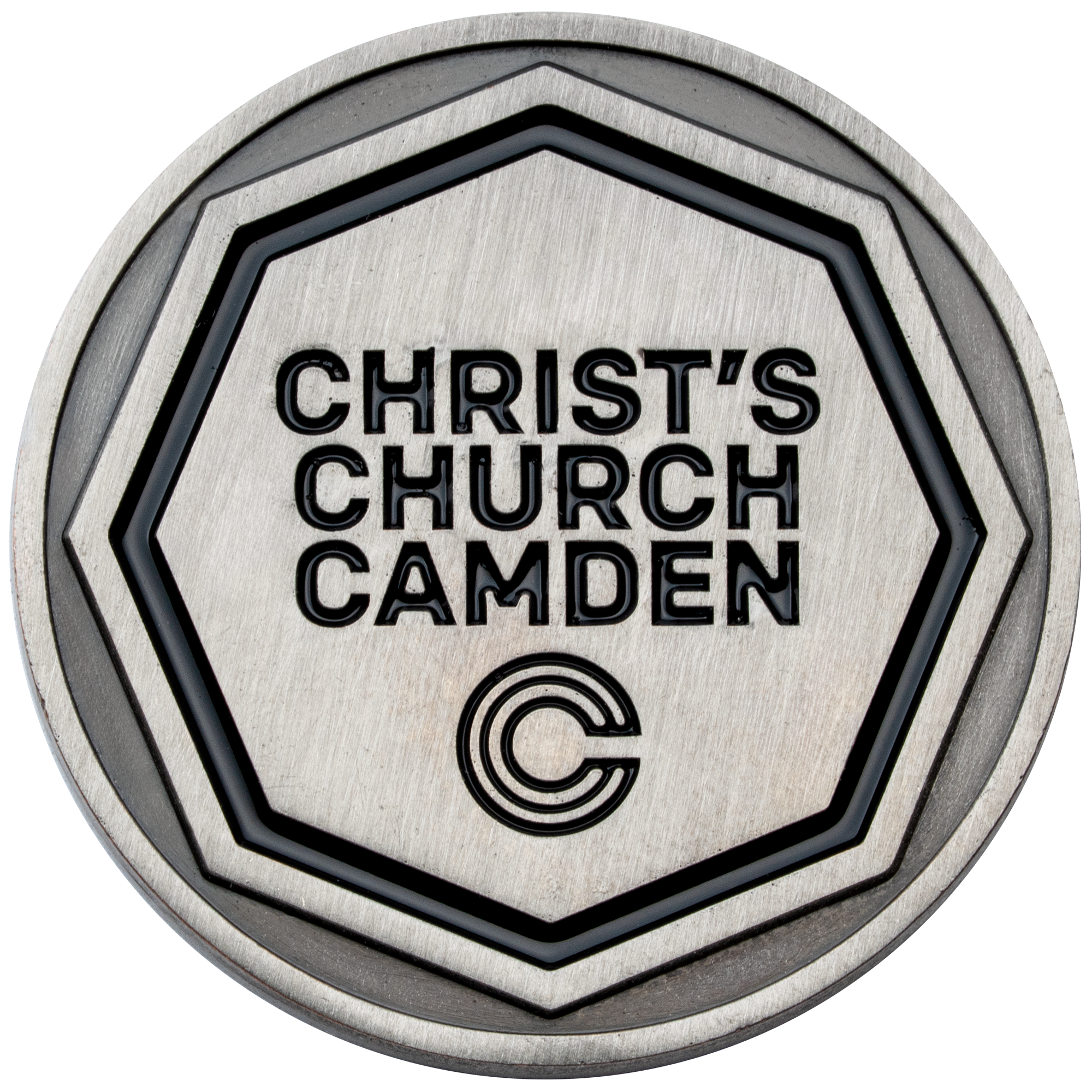 Antiqued silver challenge coin featuring Christ's Church Camden text and a circular C logo inside a recessed heptagon border with black enamel.